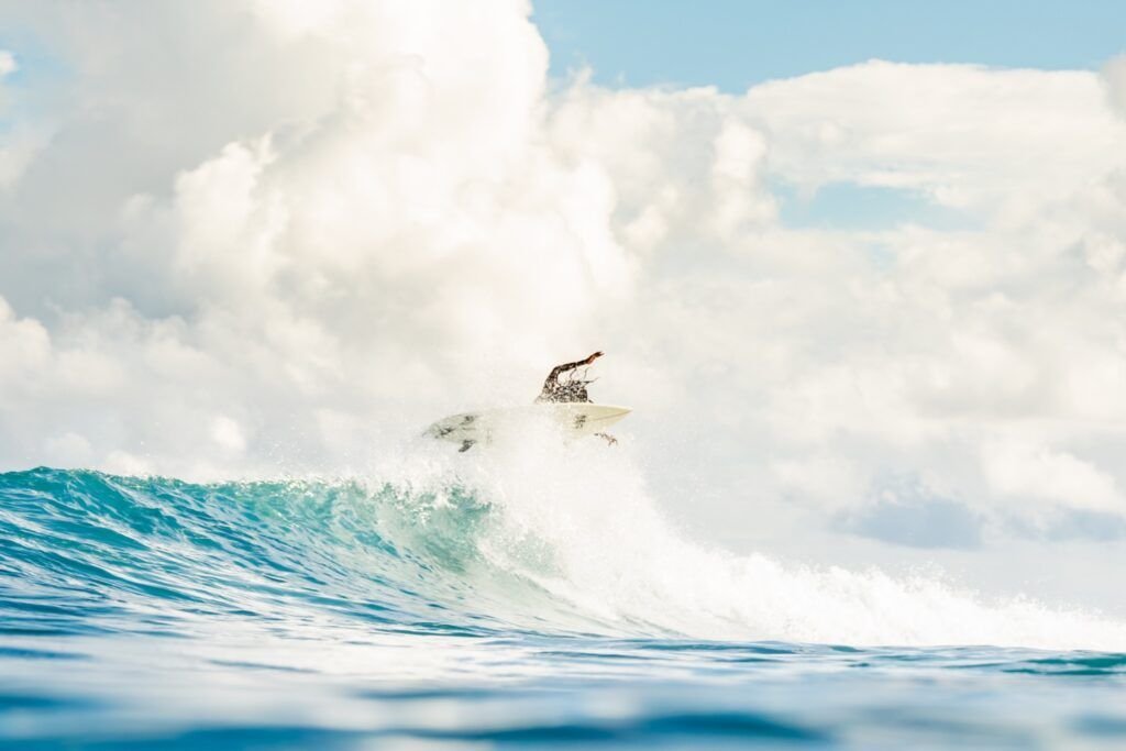 Surfer and spray above a turquoise wave