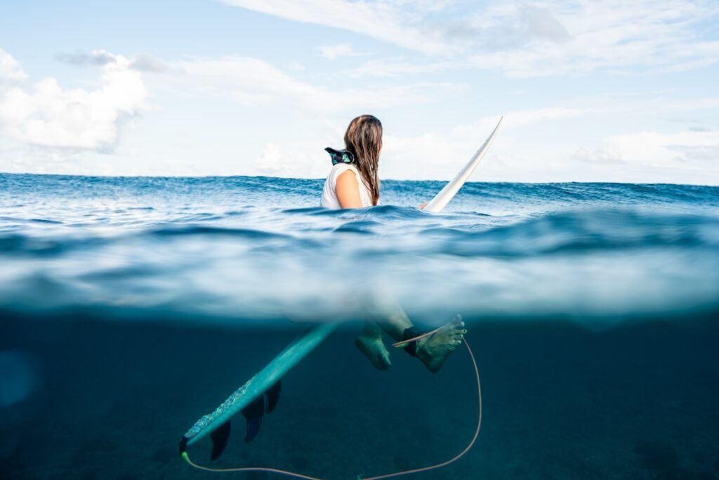 Surfer with a white surfboard in a split-level ocean photograph